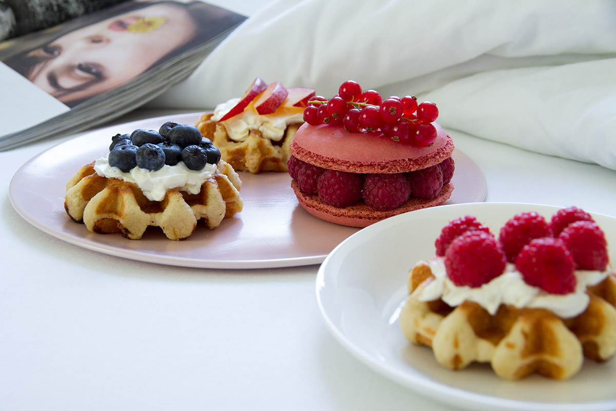 breakfast in bed plates waffles with cream cheese and fruits macaron white linen open magazine