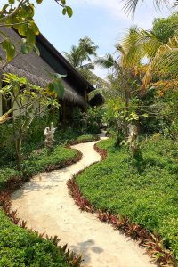 Fushifaru, spa area, huts, palms, oval pool, plants, blue sky, white clouds, sand path, blog post about Maldives on lifetime-pieces.com