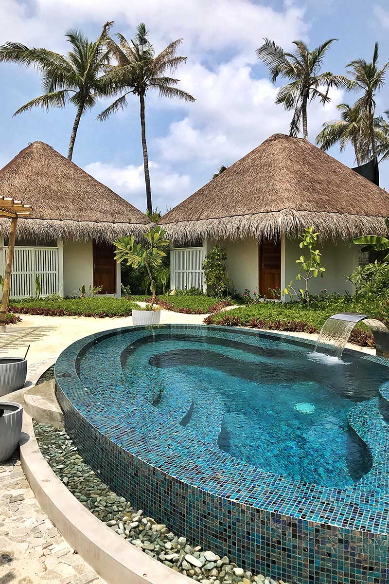 Fushifaru, spa area, huts, palms, oval pool, plants, blue sky, white clouds, blog post about Maldives on lifetime-pieces.com