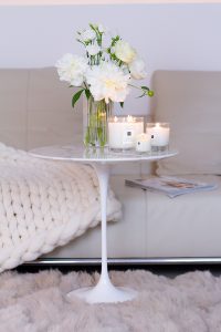Jo Malone London, living in a scented home, white Saarinen side table , three scented candles, a vase with white peonies flowers on the table