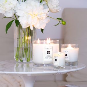Jo Malone London, living in a scented home, three scented candles, a vase with white peonies flowers on the table