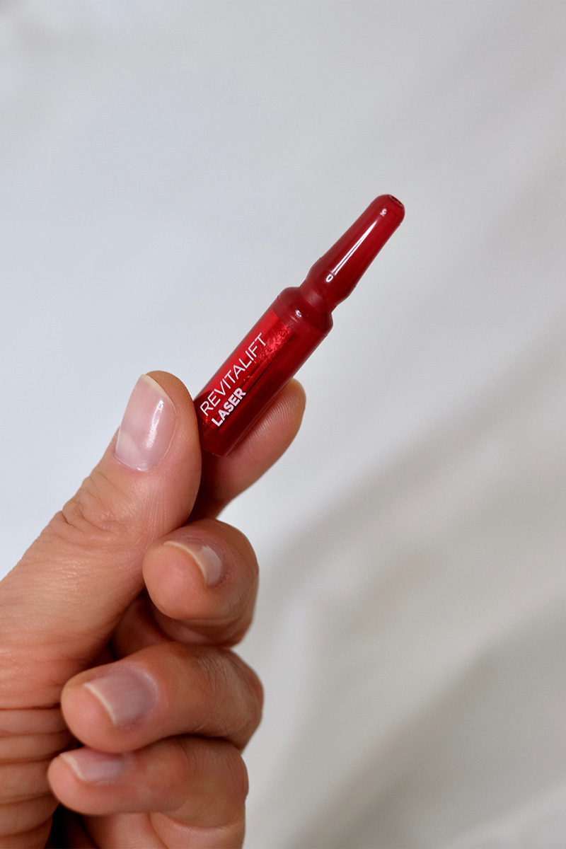 Frauenhand hält eine rote Revitalift Laser X3 Peeling Serum Ampulle - Blogbeitrag über Peelings auf www.lifetime-pieces.com